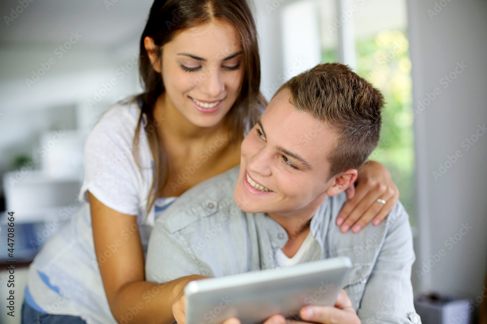 Young couple websurfing on electronic tablet Young couple websurfing on electronic tablet