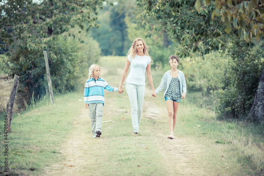 Fototapeta premium Beautiful Young Woman with Two Children Outside