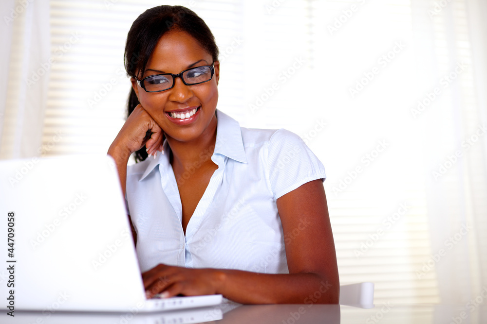 Afro-american secretary reading on laptop screen Afro-american secretary reading on laptop screen