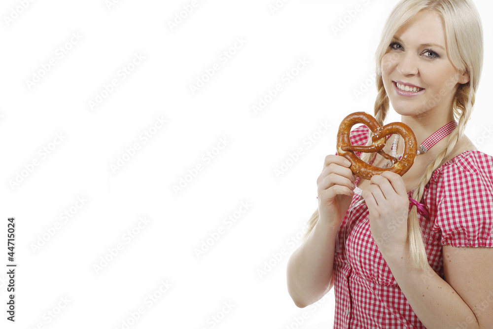 Hübsche blonde Frau mit Zöpfen und karierter Bluse hält Brezel