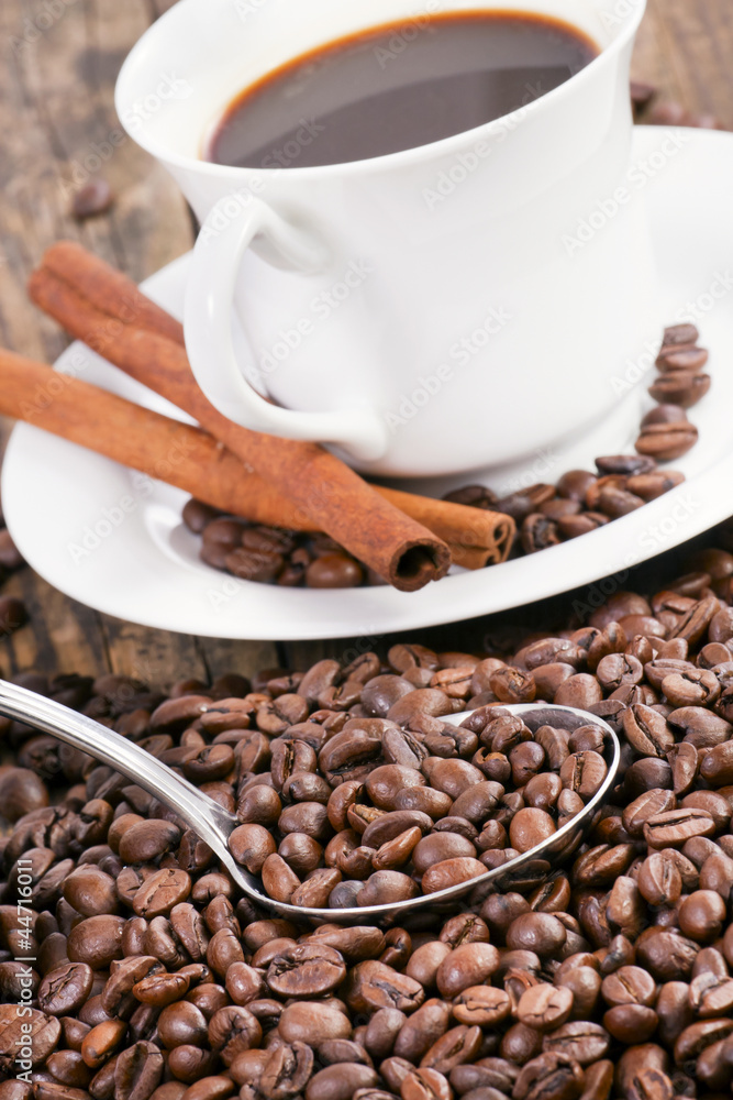 Coffee cup surrounded by coffee beans and scoop. Coffee cup surrounded by coffee beans and scoop.