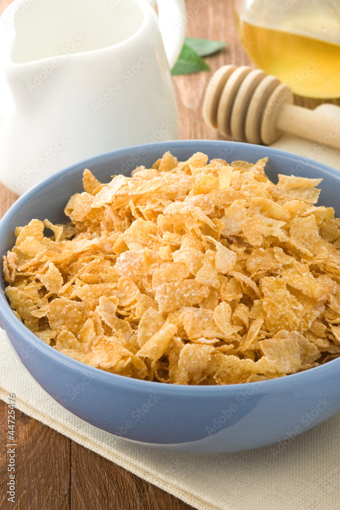 Bowl of corn flakes and milk on wood Bowl of corn flakes and milk on wood