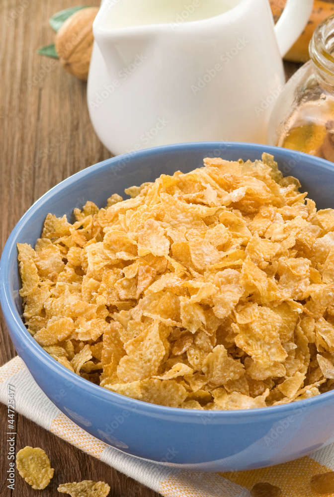 Bowl of corn flakes and milk on wood Bowl of corn flakes and milk on wood
