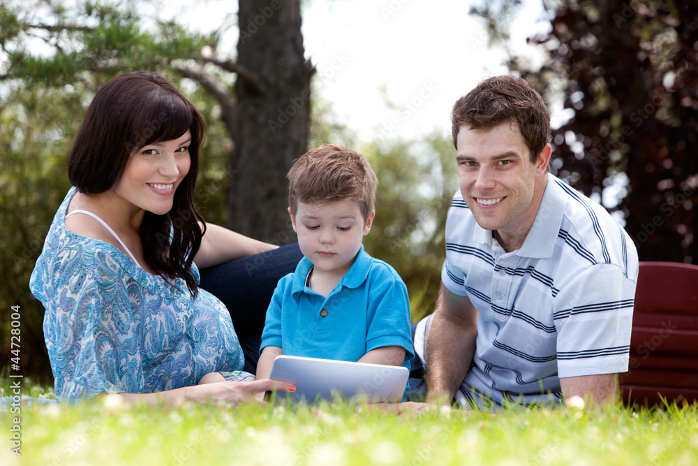 Fototapeta premium Młody chłopak z rodzicami w parku