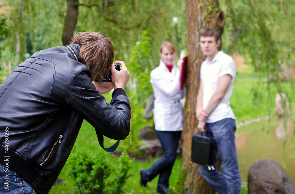 Photographer takes picture of young couple outdoors Photographer takes picture of young couple outdoors