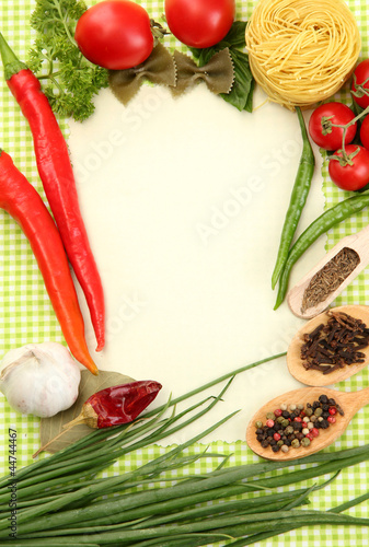 paper for recipes vegetables and spices on green background