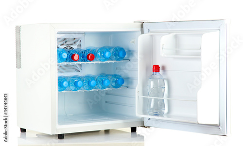 mini fridge full of bottled water isolated on white