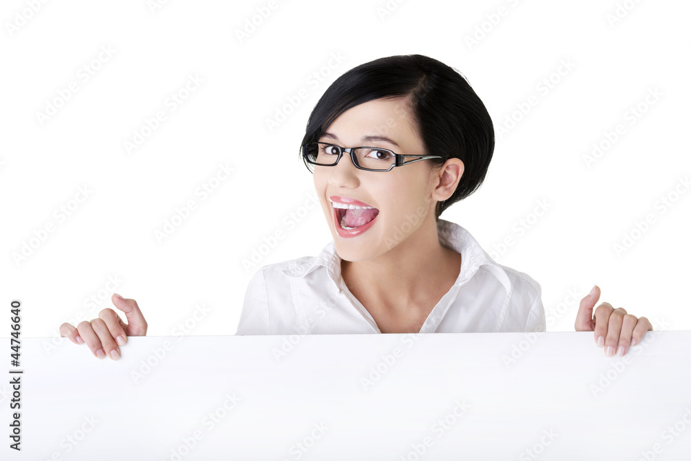 Smiling young business woman showing blank signboard