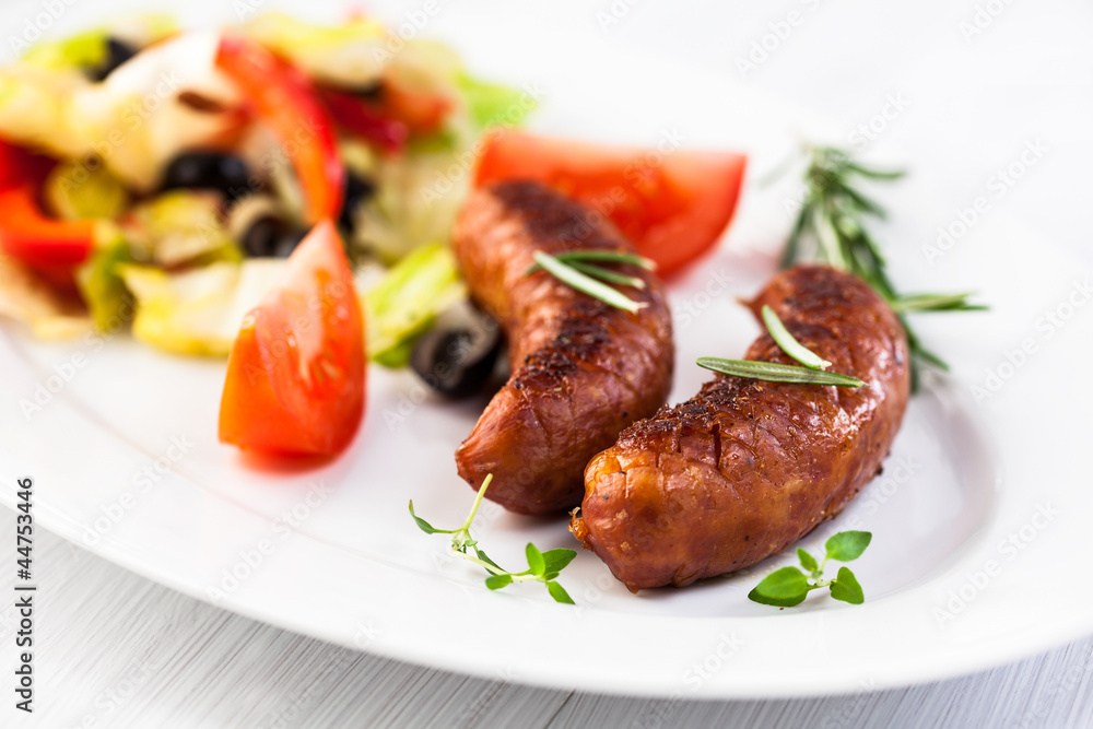 Grilled sausages with salad on a plate