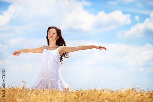 Young woman having joy in wheat field
