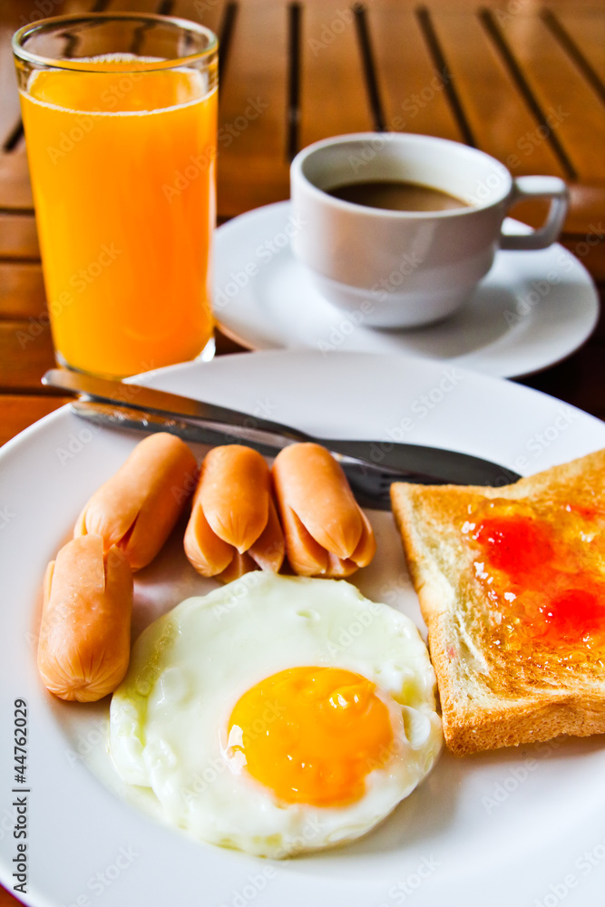 Fototapeta premium breakfast with fried eggs,sausage, toasts, juice and coffee