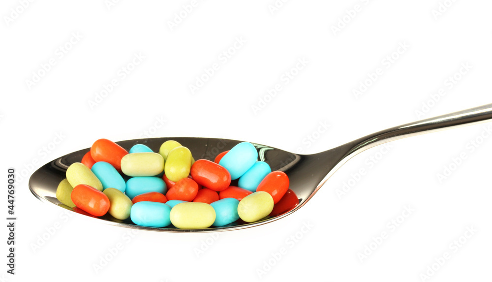 colorful pills on spoon on white background close-up colorful pills on spoon on white background close-up