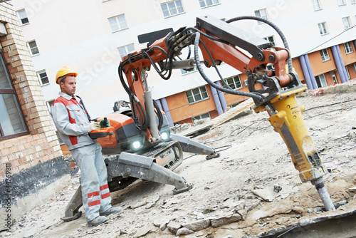 builder worker operating demolition machine