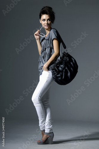 Full length Portrait of stylish professional model with handbag