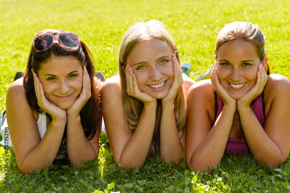 Teen women relaxing in park smiling friends Teen women relaxing in park smiling friends