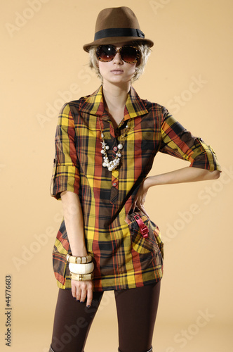 young fashion model posing wearing sunglasses- beige background © fancy123