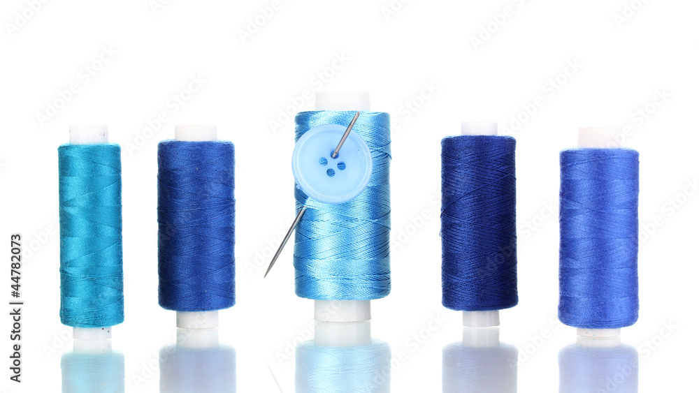 Many blue bobbin with needle and buttons isolated on white Many blue bobbin with needle and buttons isolated on white