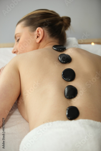 young fair-haired woman lying bare-backed on massage table