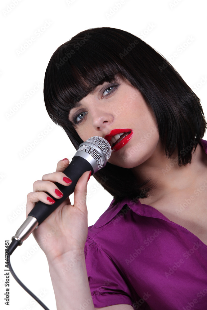 Woman singing into a microphone Woman singing into a microphone