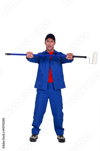 painter holding a roller on a long handle