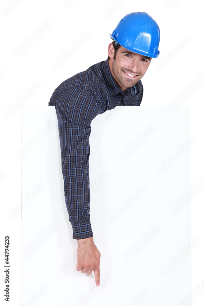 Manual worker pointing downwards at poster Manual worker pointing downwards at poster