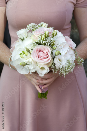 bridesmaid holding a wedding bouquet of pink flowers