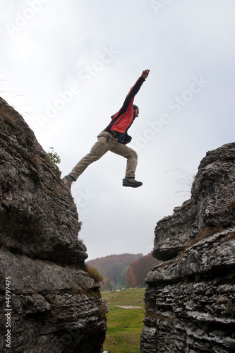 Tapety artystyczne Man jump between rock