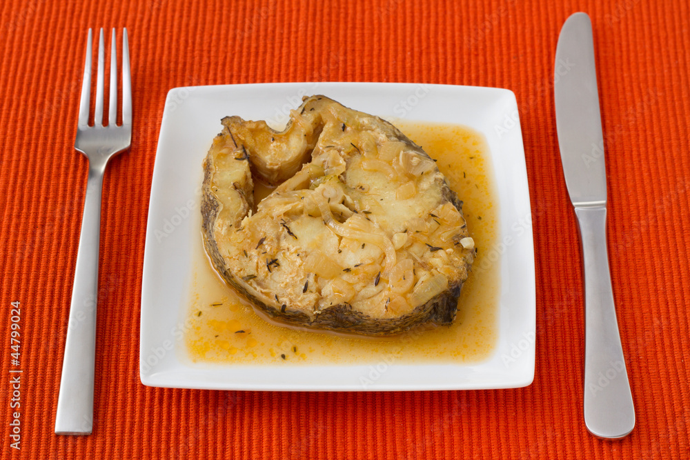 fish in sauce with onion on the plate fish in sauce with onion on the plate