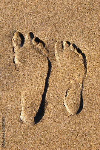 Two footprints in the sand from above