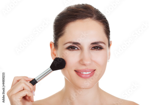 Beautiful woman applying blusher