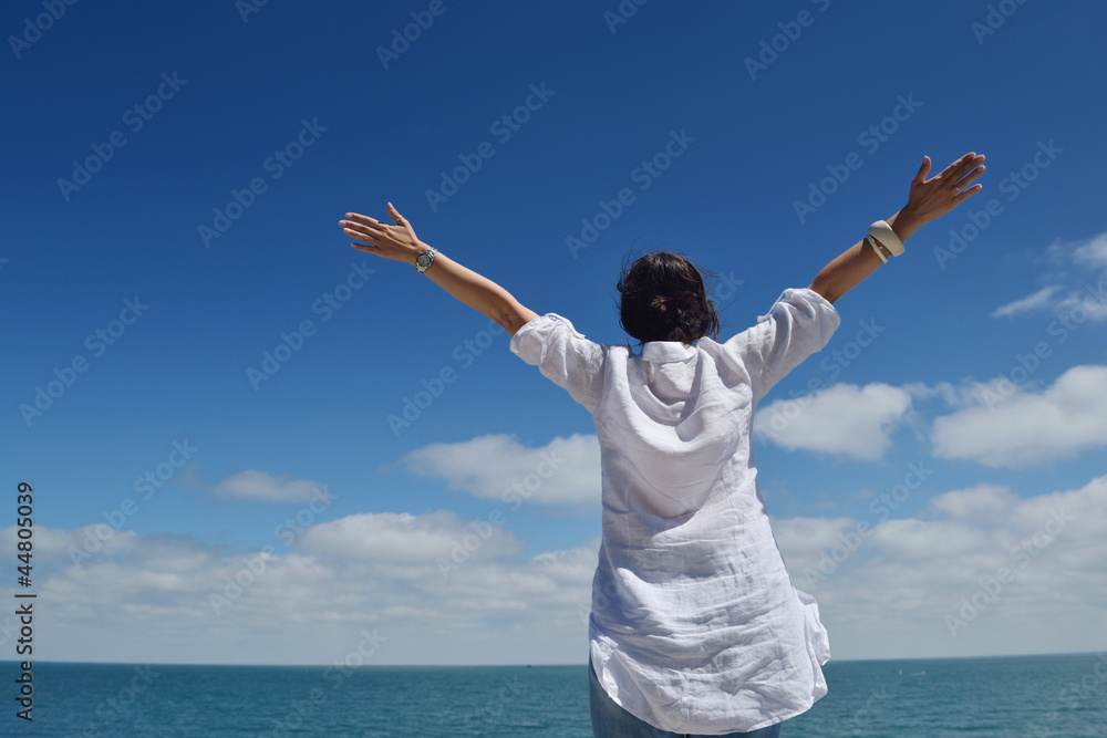 happy young woman with spreading arms to sky