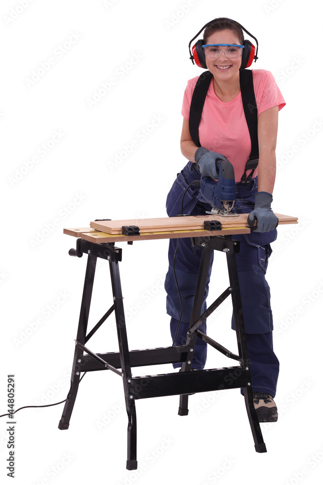 Female capenter cutting plank with electric saw Female capenter cutting plank with electric saw