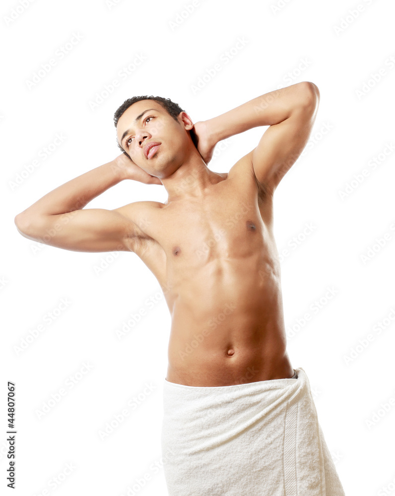 A nude young man covering himself with a towel A nude young man covering himself with a towel