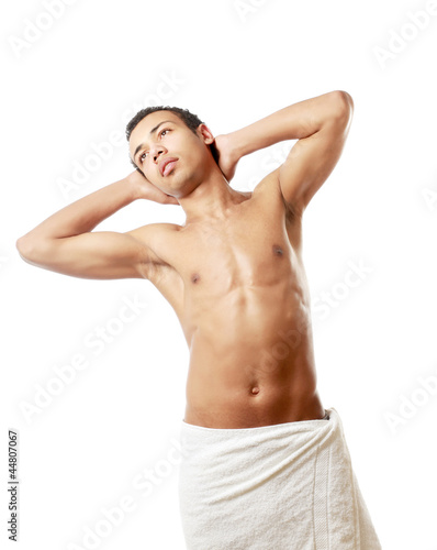 A nude young man covering himself with a towel