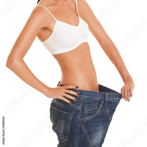 Pretty woman shows her weight loss by wearing an old jeans