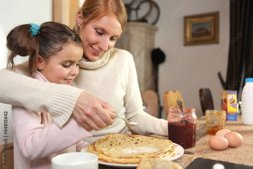 loving mother making crepes with little girl loving mother making crepes with little girl