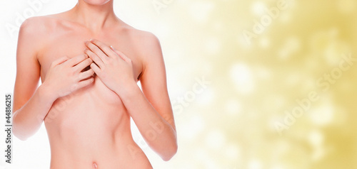 nude young female covering her breast with her hands