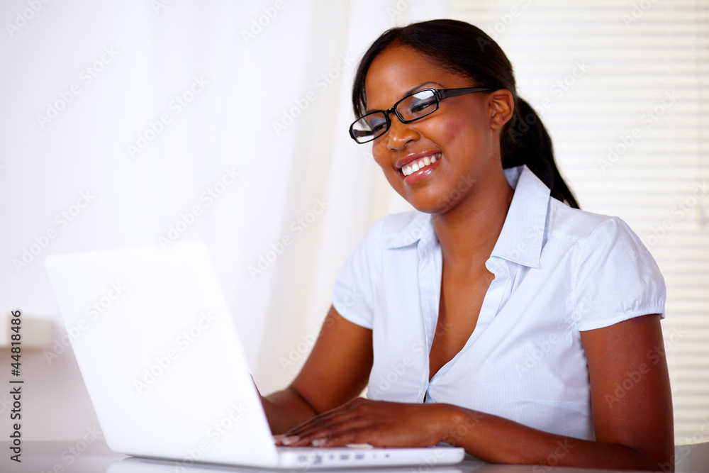 Lovely young woman smiling and looking to laptop Lovely young woman smiling and looking to laptop