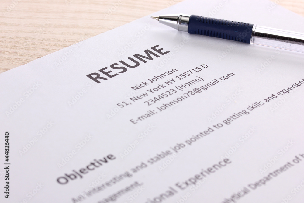 Closeup of resume with pen on wooden table Closeup of resume with pen on wooden table