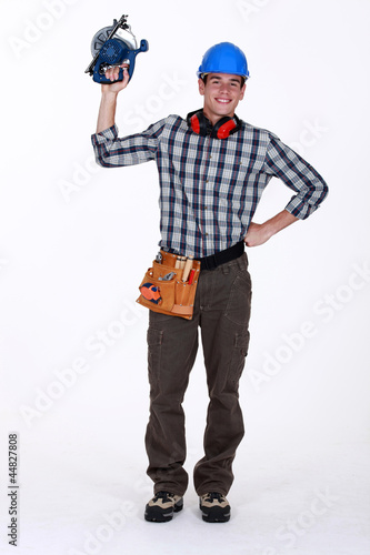 Young construction worker with a circular saw