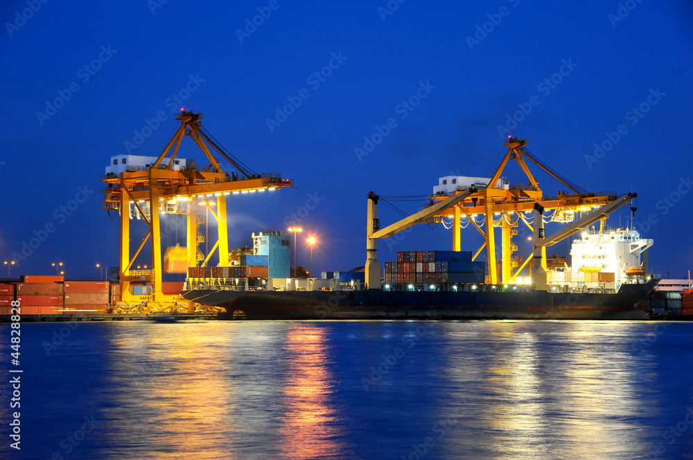 Container Cargo freight ship with working crane bridge in shipya