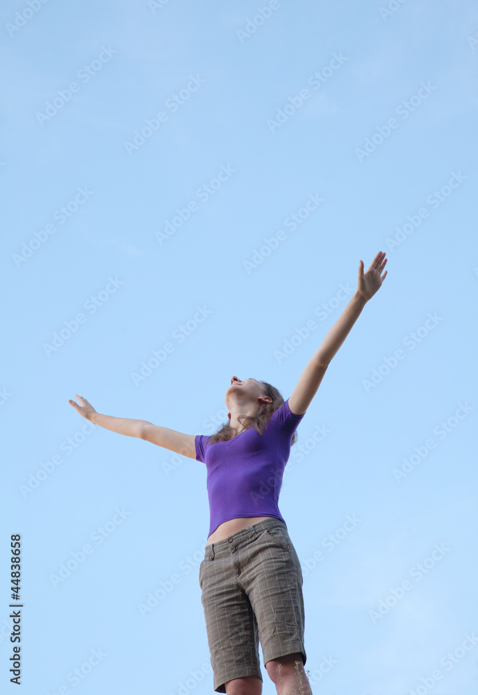 Young woman sitting with raised hand Young woman sitting with raised hand