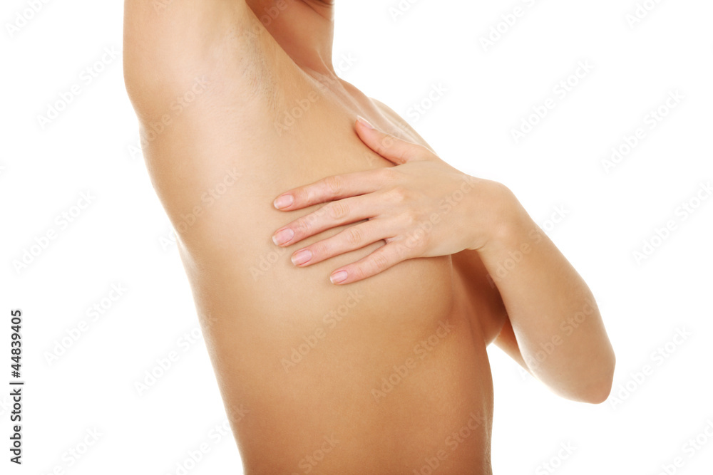 Woman examining her breast for lumps or breast cancer