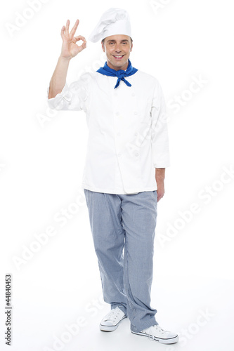 Full length portrait of chef showing okay sign