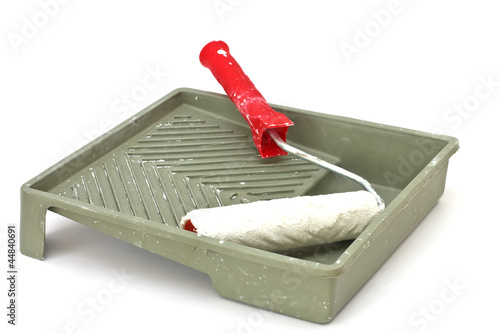 Old paint roller and tray isolated on white