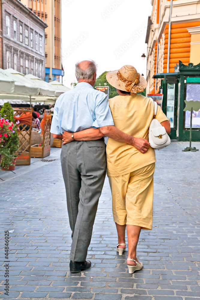 Old couple walking at Piata Sfatului in Brasov, Romania.