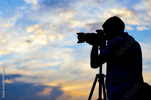 Silhouette of a photographer taking a picture in sunset