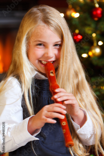 girl playing recorder on christmas eve photo