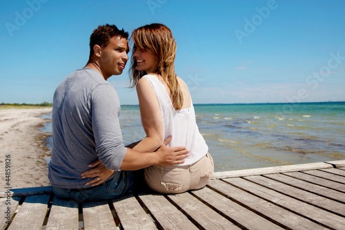 Attractive Couple Sitting on a Pier