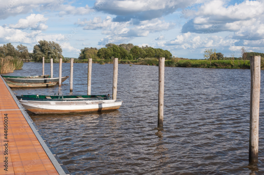 Colorful view at a modern jetty and old rowing boats